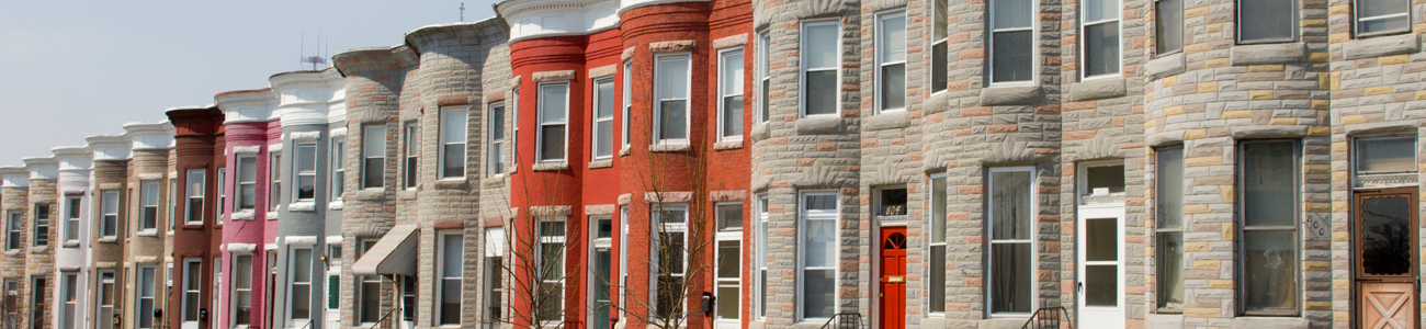 A row of traditional townhouses with distinctive stone facades and colorful doors.
